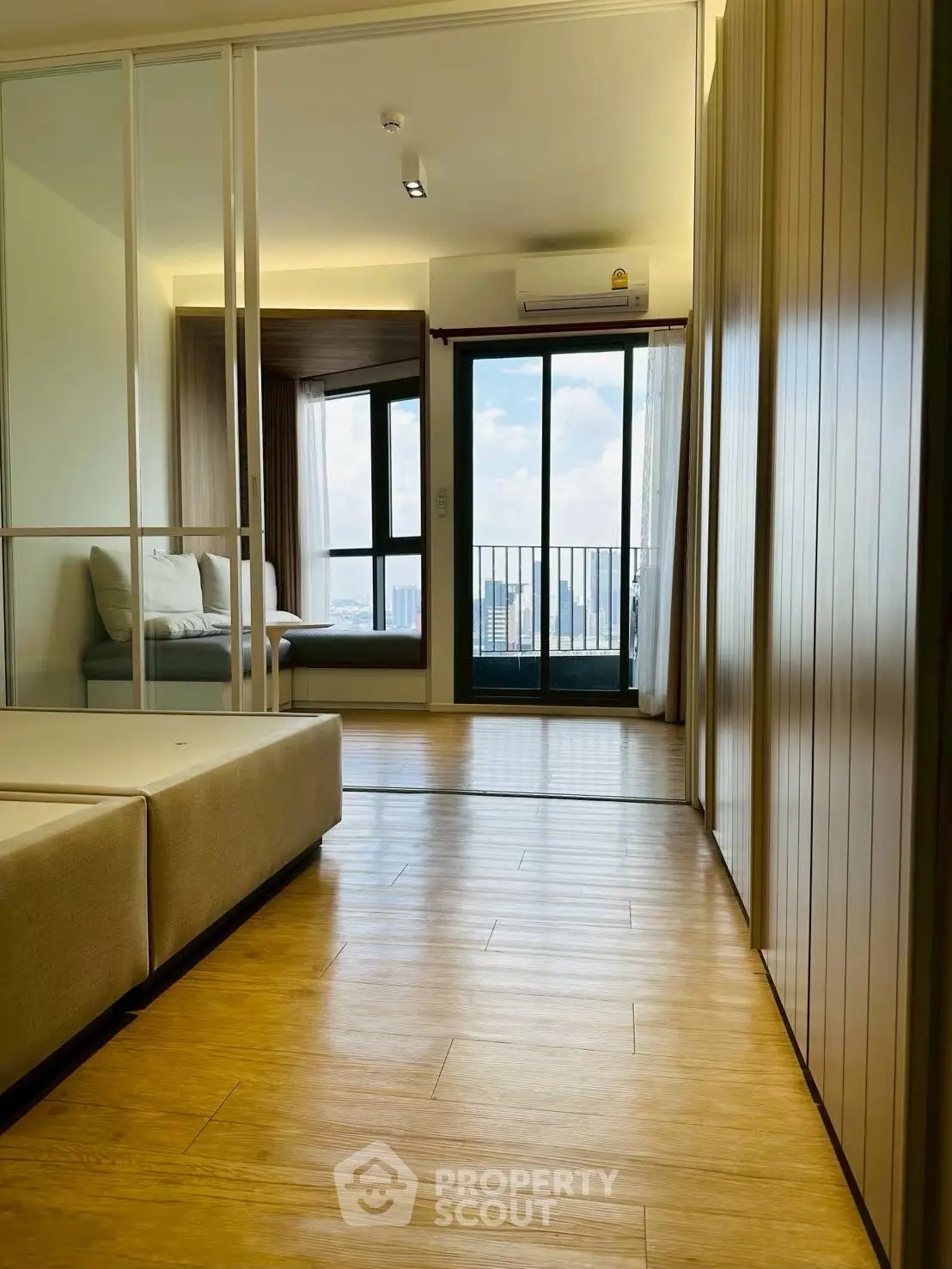 Modern apartment interior with wooden flooring and balcony view