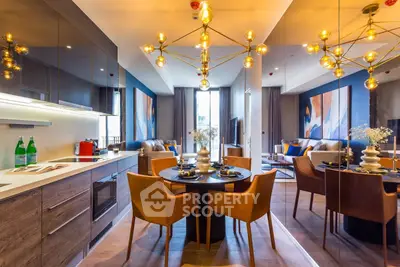 Luxurious open-plan kitchen and living area with modern decor and elegant lighting fixtures.