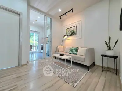 Modern living room with stylish decor and natural light, featuring a cozy sofa and elegant flooring.