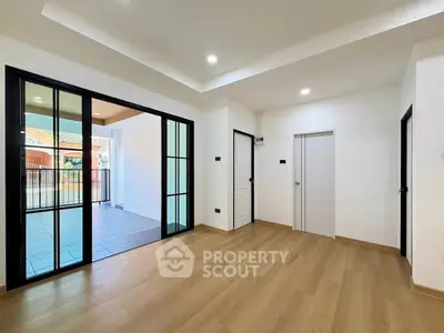 Spacious modern living room with sliding glass doors and wooden flooring