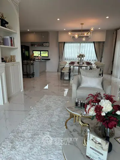 Luxurious open-plan living and dining area with elegant decor and modern lighting.