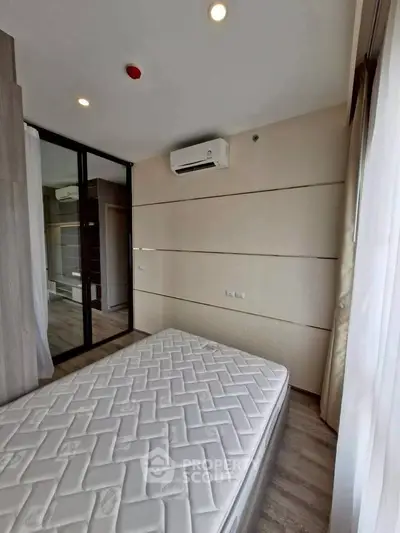 Modern bedroom with large window and air conditioning unit, featuring a comfortable mattress and sleek design.