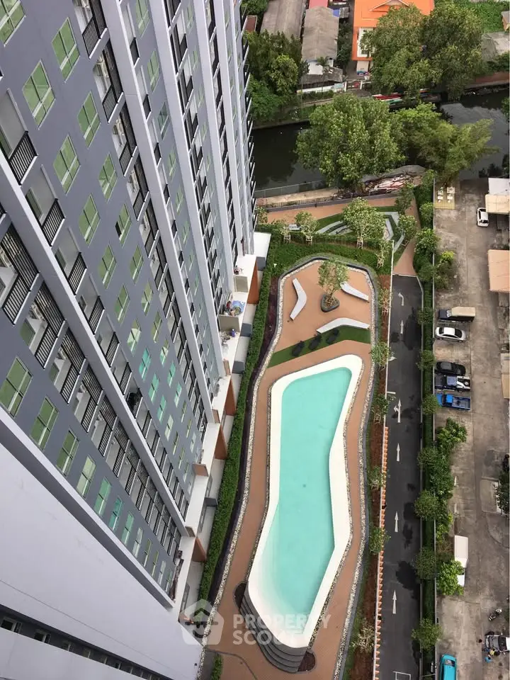 Stunning aerial view of modern high-rise building with elegant pool and lush greenery, perfect for urban living.