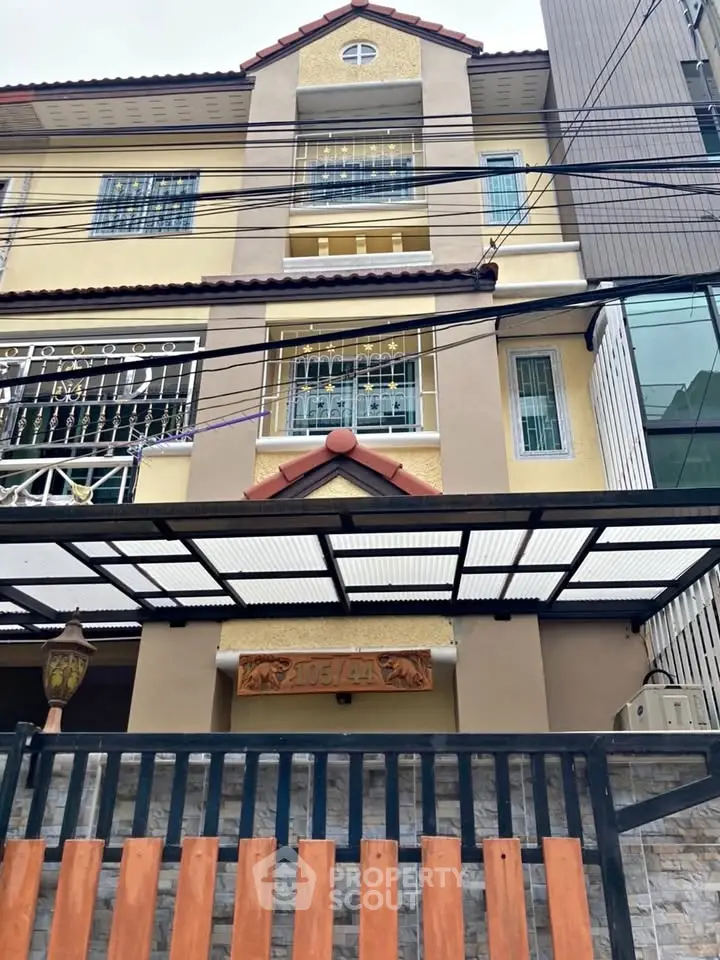 Charming multi-story residential building with unique architectural details and gated entrance.