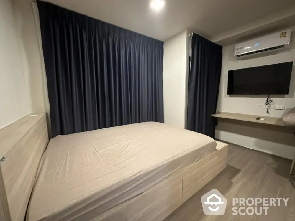 Modern bedroom with sleek design, featuring a comfortable bed and air conditioning.