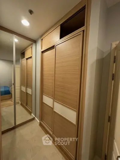 Spacious walk-in closet with wooden sliding doors and mirrored panels in modern home.