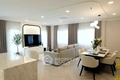 Luxurious open-plan living room with modern decor and elegant dining area.