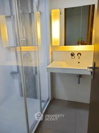 Modern bathroom with sleek glass shower and illuminated mirror