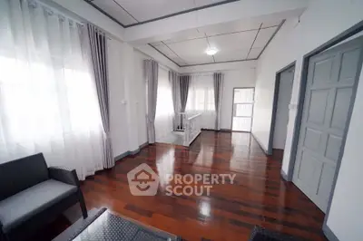 Spacious living room with elegant wooden flooring and modern decor.