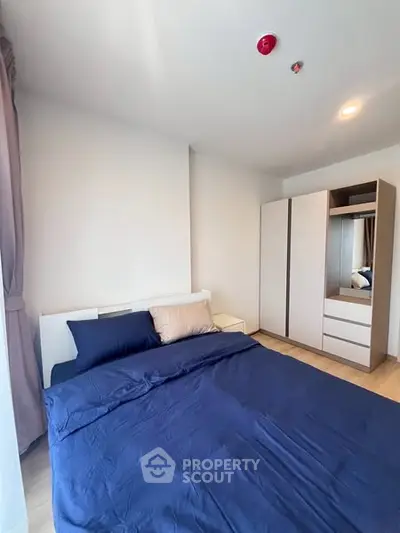 Modern bedroom with sleek wardrobe and cozy bedding in a bright apartment