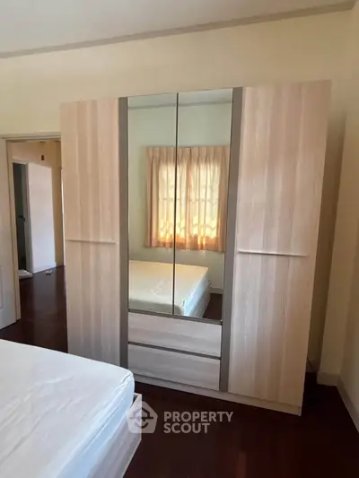 Spacious bedroom with elegant wardrobe and natural light through window