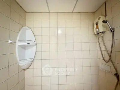 Simple bathroom with tiled walls and shower heater