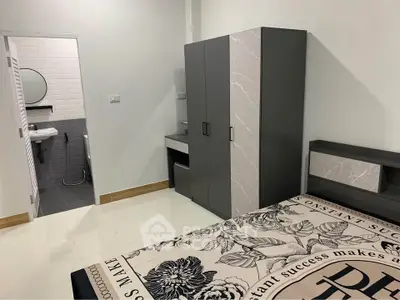 Modern bedroom with sleek furniture and ensuite bathroom, ideal for urban living.