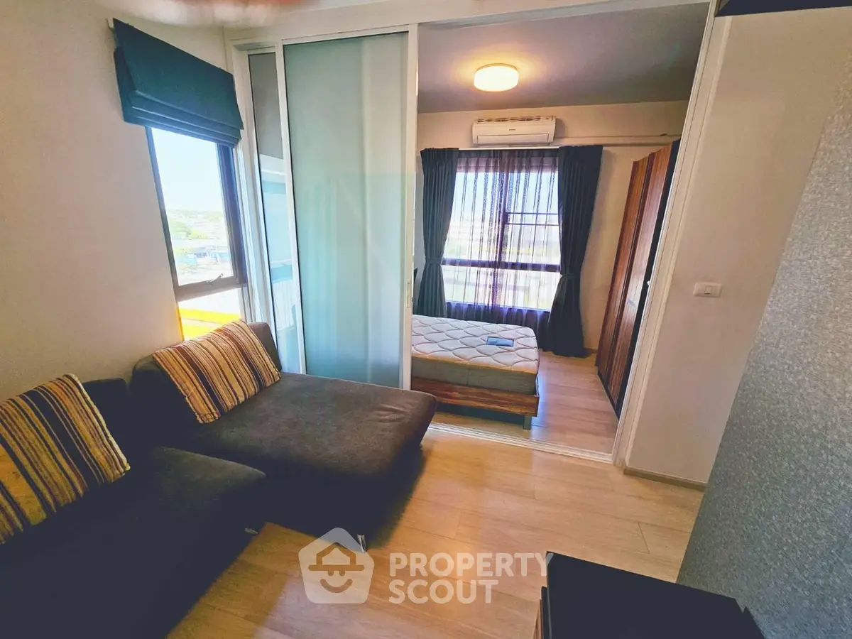 Cozy apartment with sliding glass doors separating living room and bedroom, featuring modern decor.