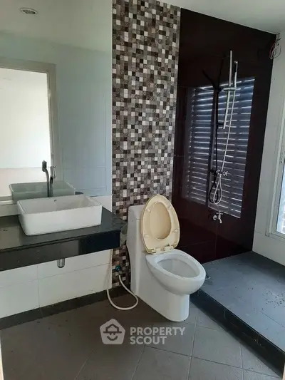 Modern bathroom with stylish tile accent wall and sleek fixtures