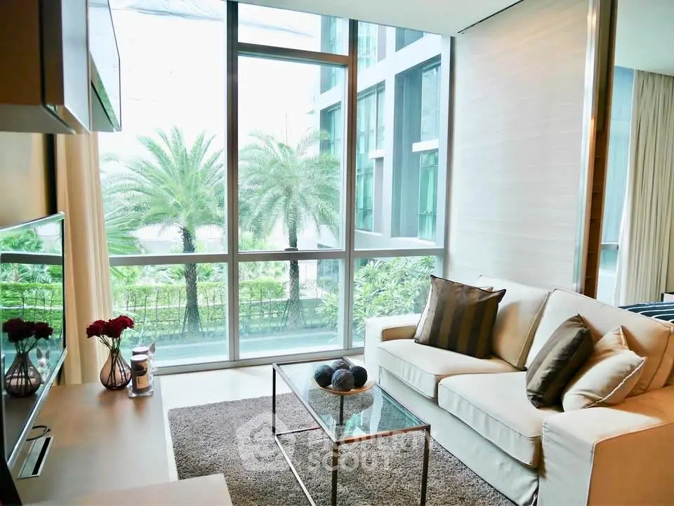 Modern living room with large windows and garden view, featuring elegant decor and comfortable seating.