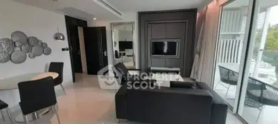 Modern living room with sleek black furniture and large windows offering natural light.