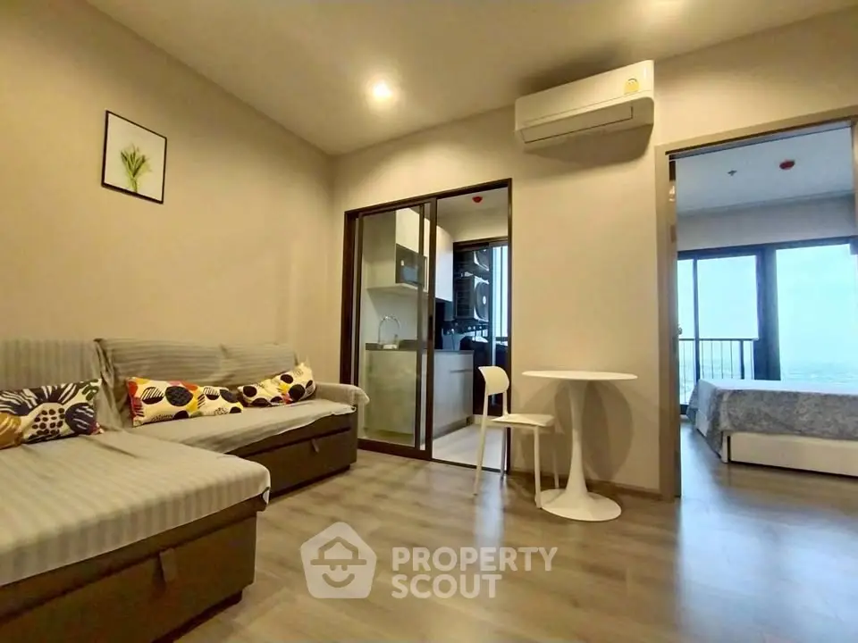 Modern apartment interior with open living room and kitchen, featuring stylish decor and natural light.