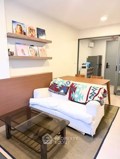 Modern living room with cozy sofa, stylish decor, and open kitchen layout in a contemporary apartment.