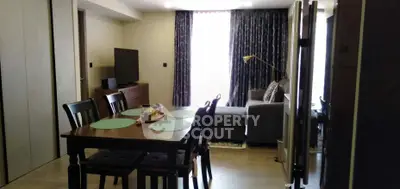 Modern living room with dining area, featuring elegant furniture and natural light.