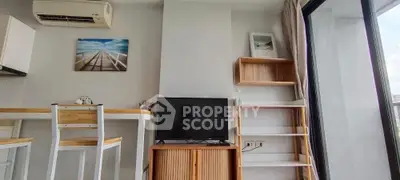 Modern living room with stylish furniture and natural light, featuring a TV and air conditioning.