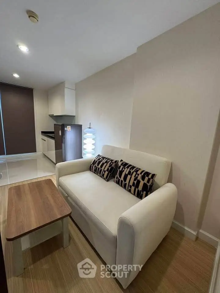 Cozy living room with modern sofa and stylish kitchen in open layout apartment.
