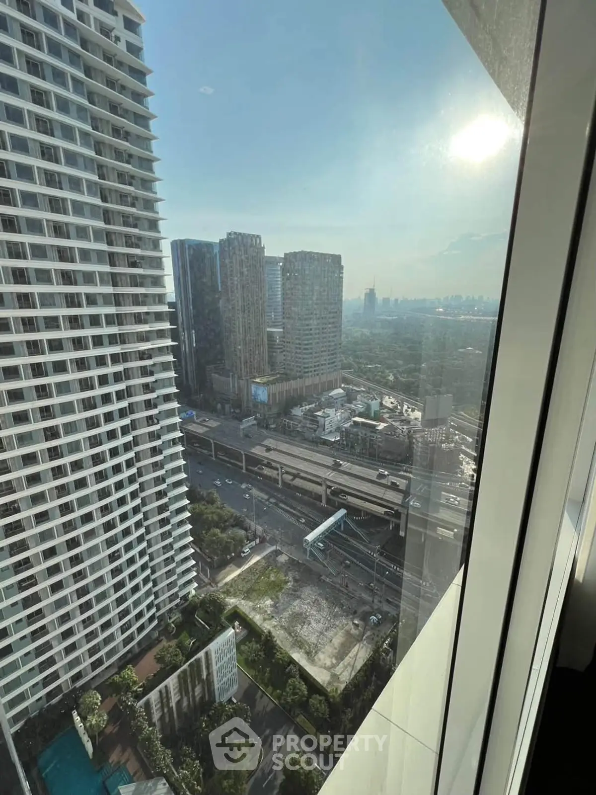 Stunning cityscape view from high-rise apartment window, showcasing urban skyline and modern architecture.