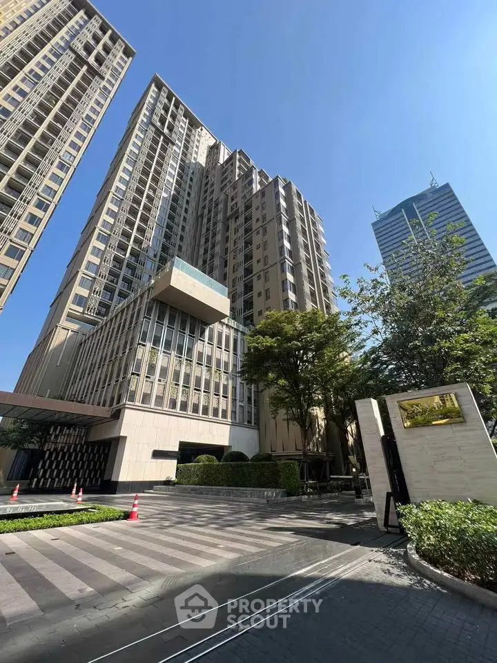 Stunning modern high-rise building with sleek architecture and lush landscaping in urban setting.