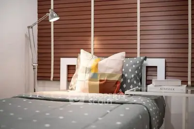Cozy bedroom with stylish decor and modern lighting, perfect for relaxation.