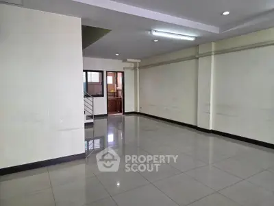 Spacious empty room with tiled flooring and natural light, ideal for customization.