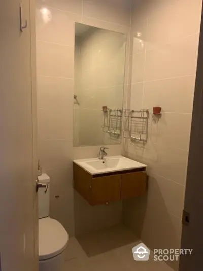 Modern bathroom with sleek vanity and large mirror in contemporary apartment.