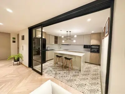 Modern open kitchen with island and stylish lighting in elegant apartment.