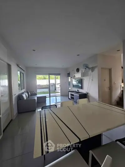 Spacious modern living room with sleek furniture and large windows offering natural light.