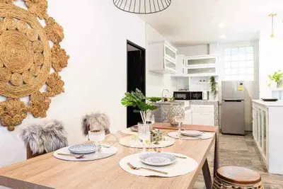 Stylish dining area with modern kitchen, featuring elegant decor and stainless steel appliances.