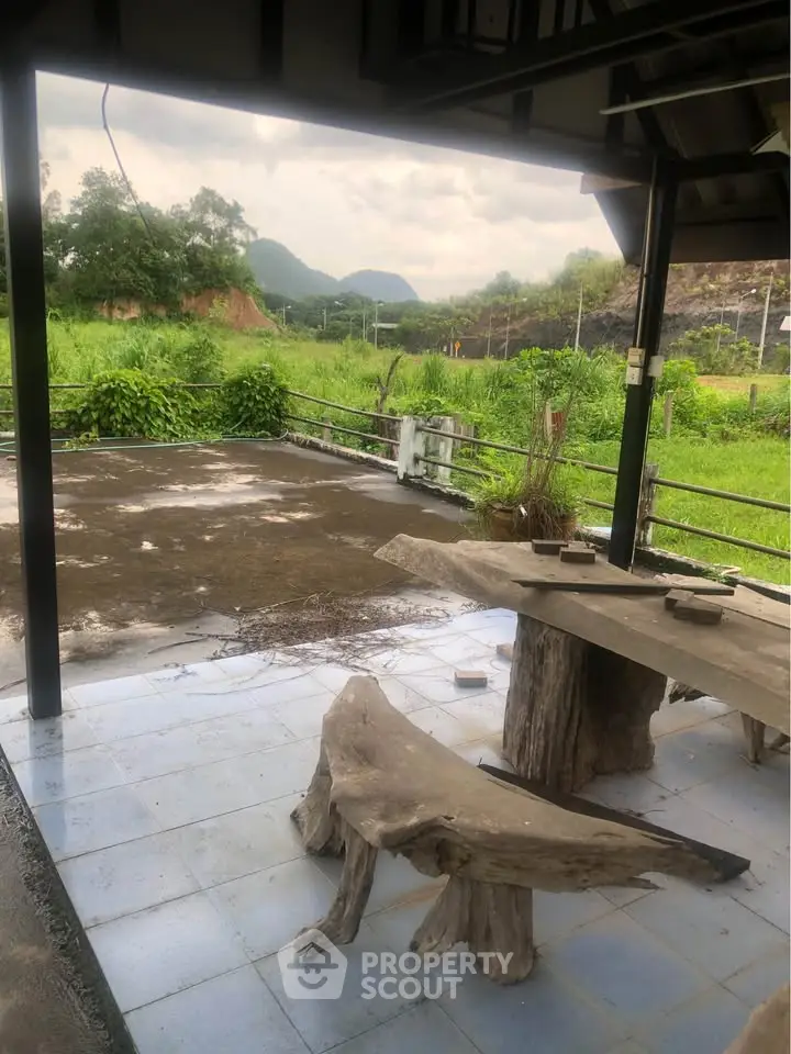 Charming rustic patio with natural wood furniture and scenic countryside view