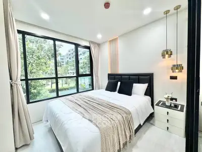 Modern bedroom with large window and stylish decor in a luxury apartment.