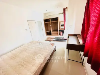 Bright bedroom with red curtains and modern furniture, featuring a comfortable bed and spacious wardrobe.