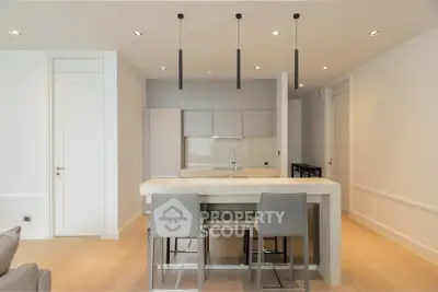 Modern kitchen with sleek design, featuring an island and stylish pendant lighting.