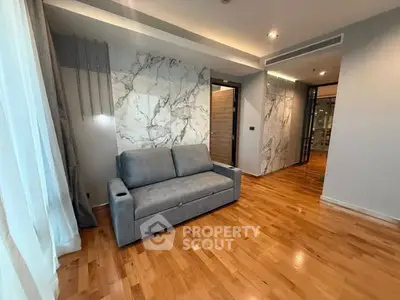 Modern living room with elegant marble accents and cozy gray sofa.