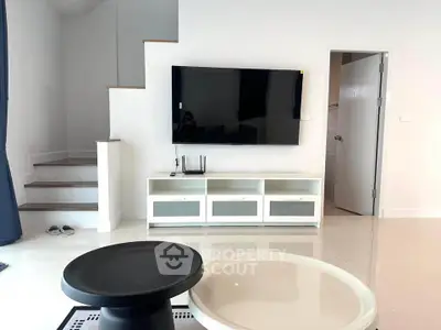 Modern living room with wall-mounted TV and sleek furniture