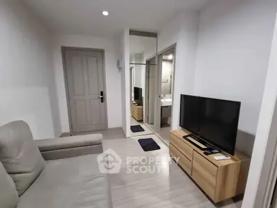 Modern living room with sleek furniture and TV, featuring a minimalist design and neutral tones.