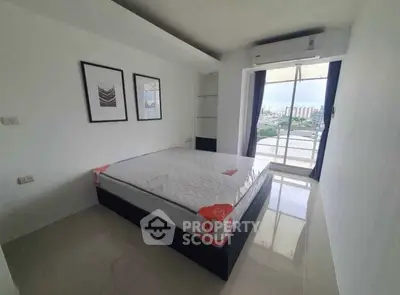 Modern bedroom with large window and city view, featuring a new mattress and air conditioning.