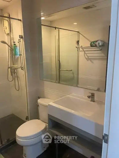 Modern bathroom with glass shower and sleek fixtures in a contemporary apartment.