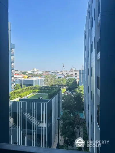 Modern urban apartment view with lush greenery and clear blue sky