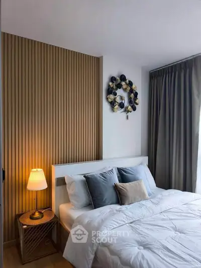 Cozy bedroom with modern decor and soft lighting, featuring a stylish accent wall and elegant curtains.