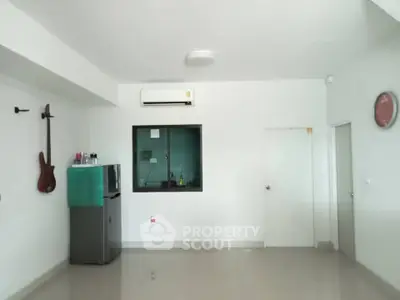 Spacious minimalist room with air conditioning and wall-mounted guitar