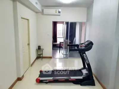 Spacious room with treadmill and mirrored closet in modern apartment