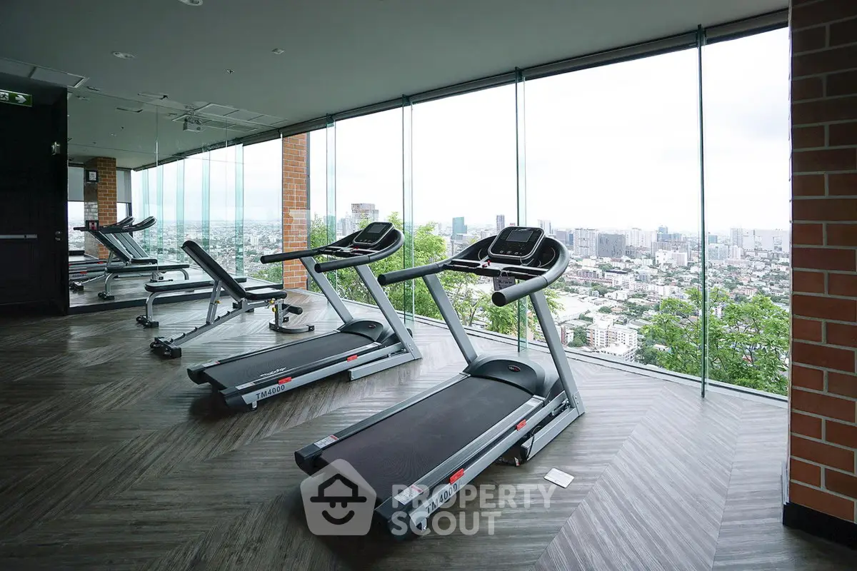 Luxurious high-rise gym with panoramic city views and modern fitness equipment.