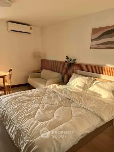 Cozy bedroom with stylish decor and natural light, featuring a comfortable bed and modern furnishings.