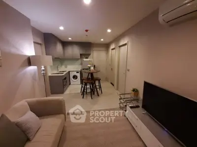 Modern living room with open kitchen, featuring cozy seating and stylish decor.